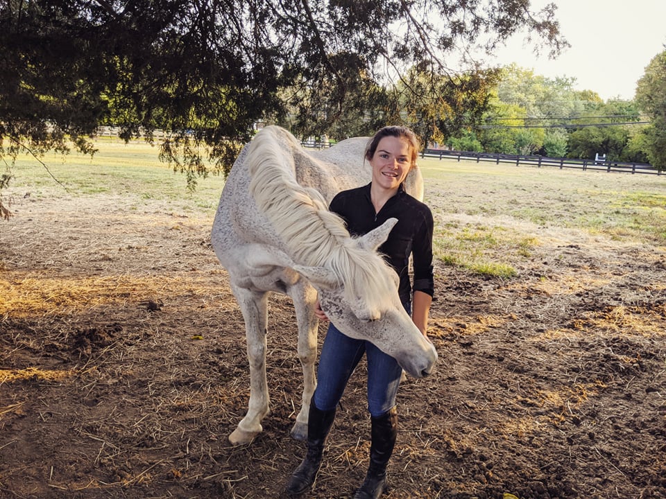 Picture of me next to a gray horse nuzzling me